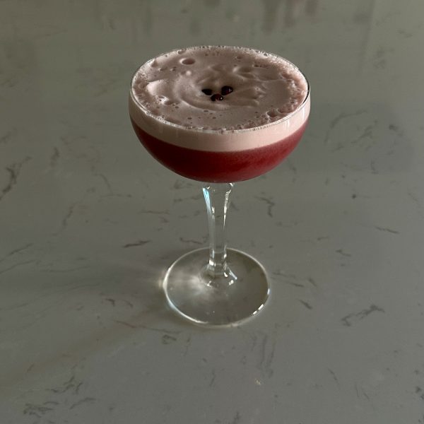 pomegranate sour topped with three pomegranate seeds
