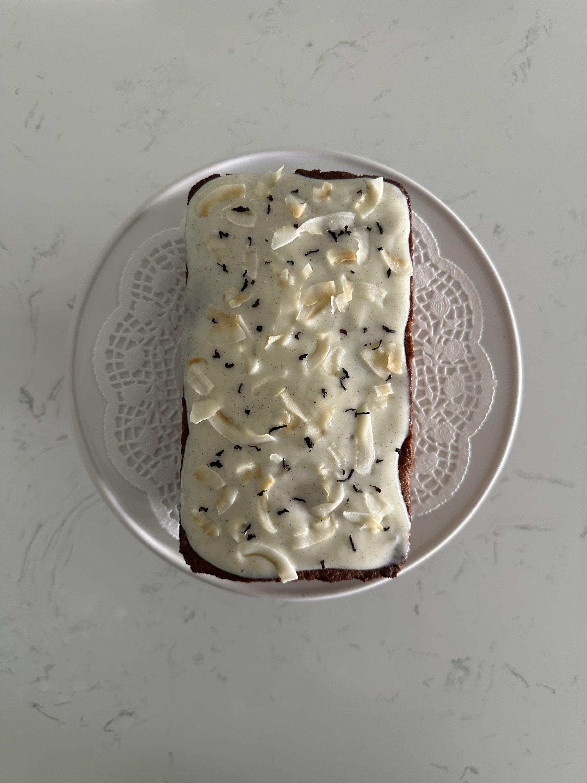 earl gray coconut pound cake with a sour cream glaze decorated with earl gray tea leaves and toasted coconut chips. 