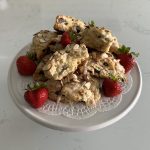strawberry scones, with fresh strawberries decorated around them, on a cake stand